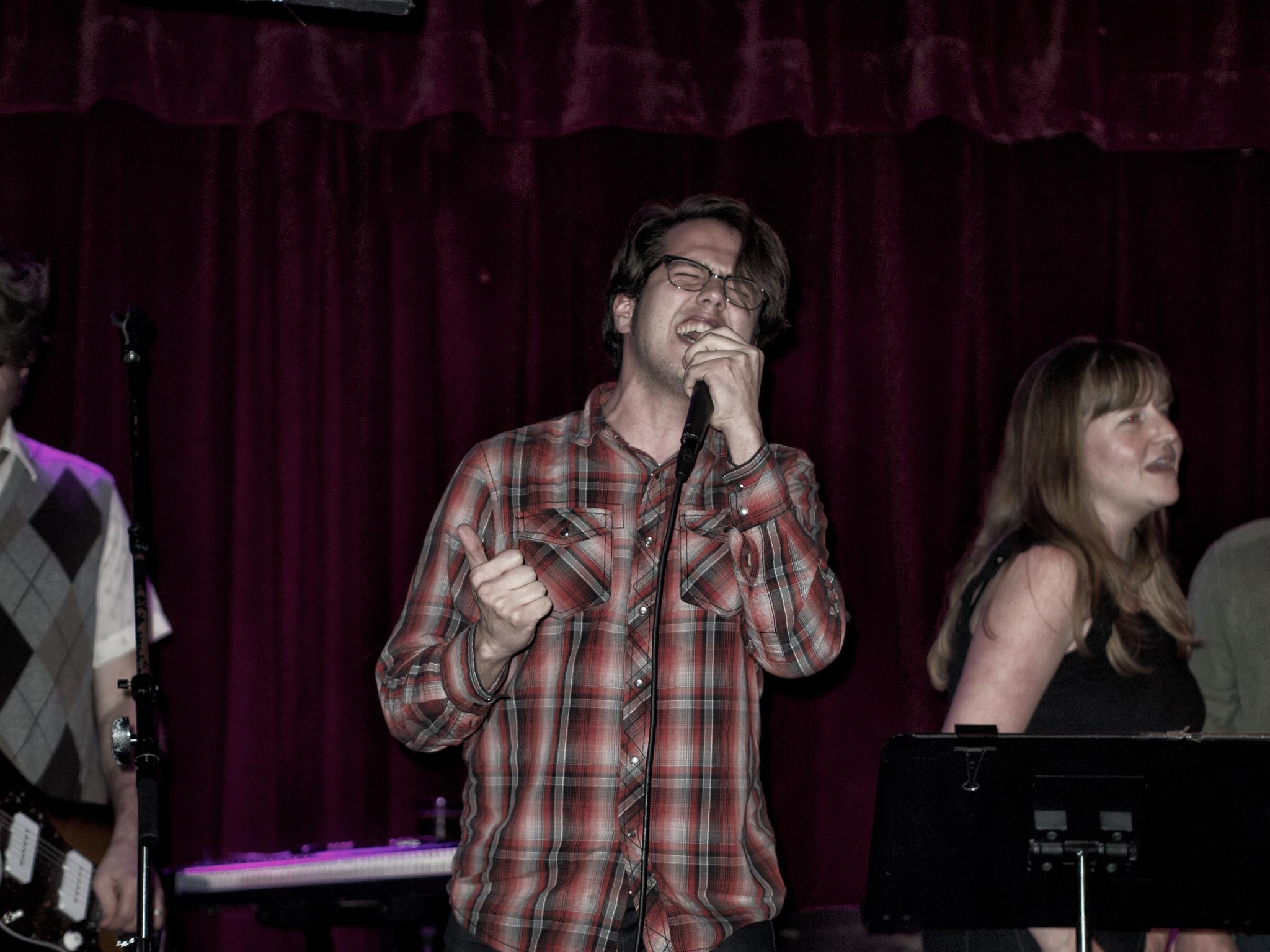 Justin belting out a song at live-band karaoke